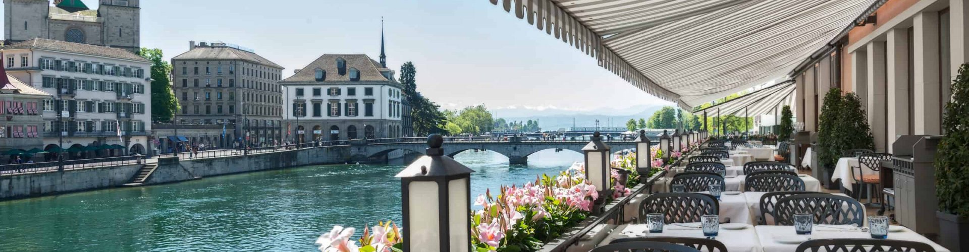 Evening riverside shot of Zürich lit up against twilight